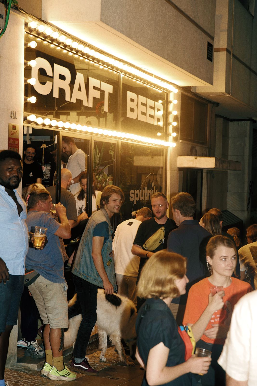 A crowd outside a bar at night during a DJ set