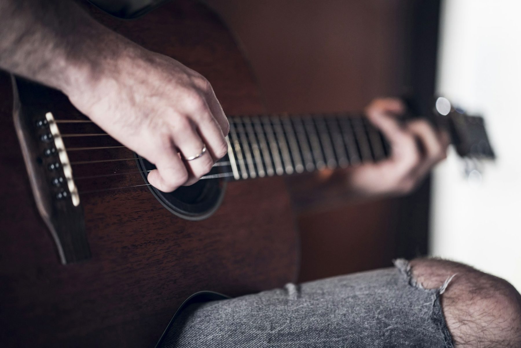 Hands playing an acoustic guitar
