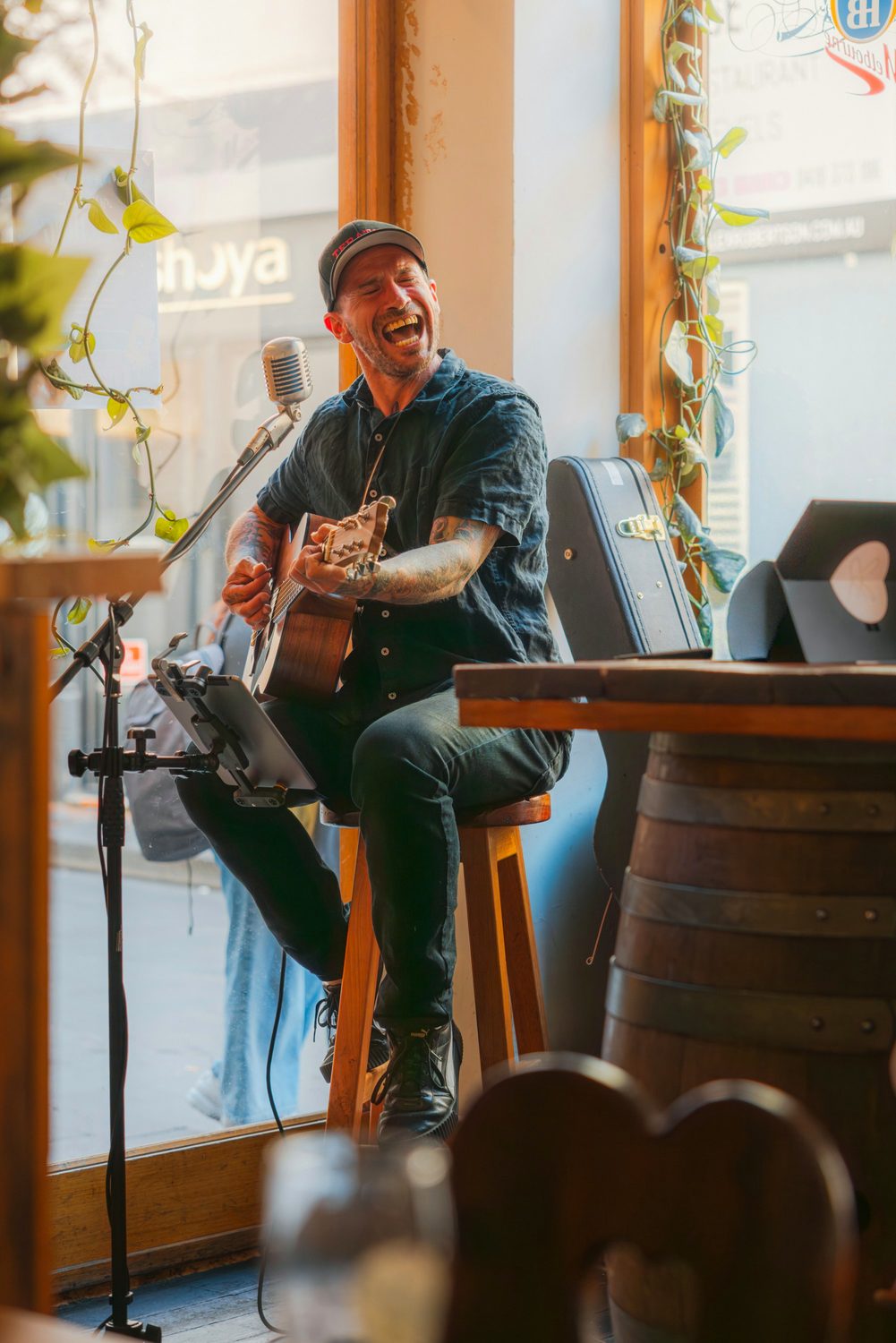 A man playing guitar and singing at a venue