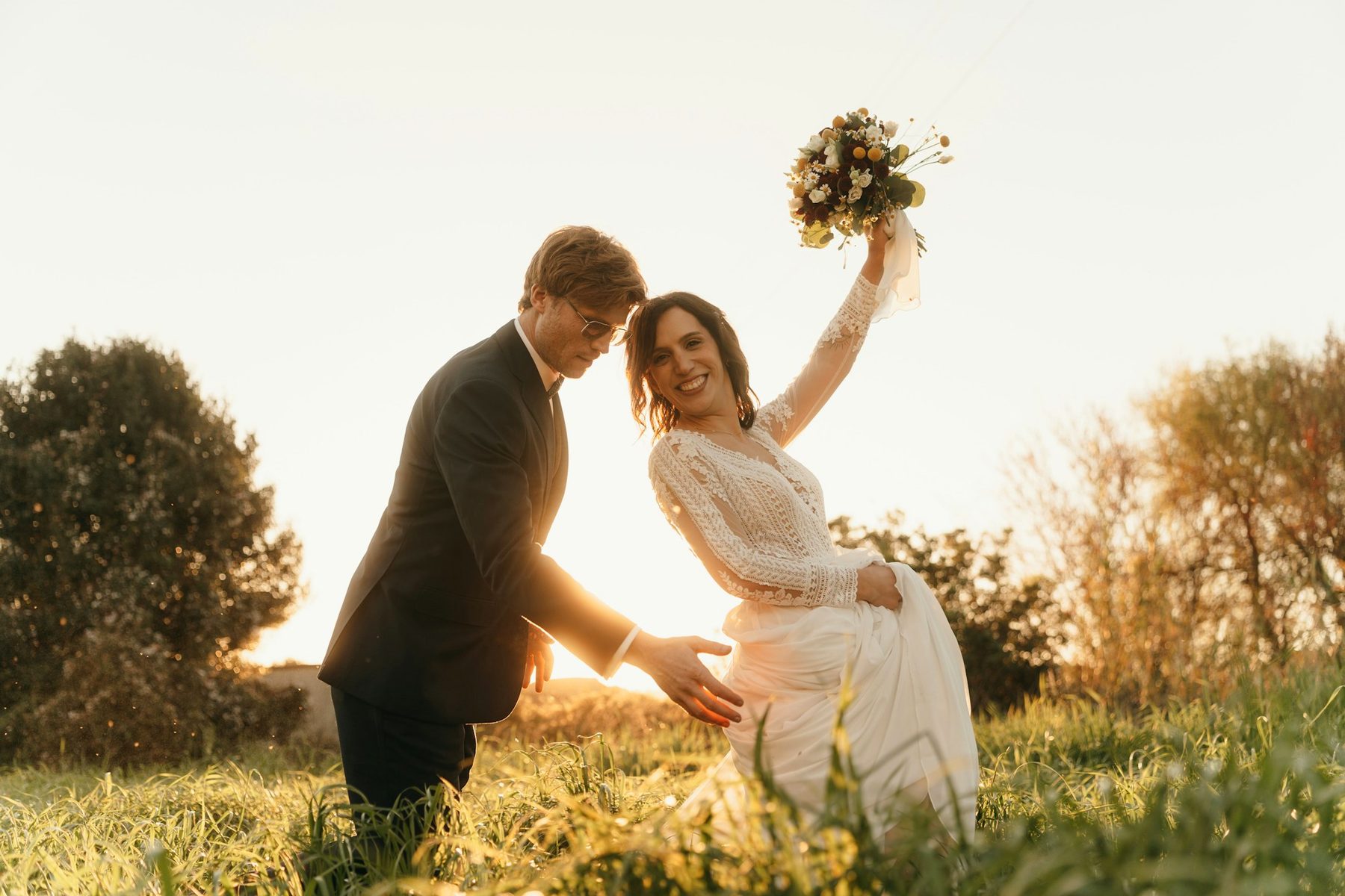 A couple laughing together in a sunlit field
